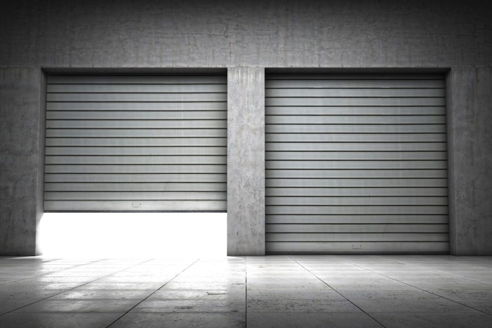 Two garage doors in a building with no one inside.