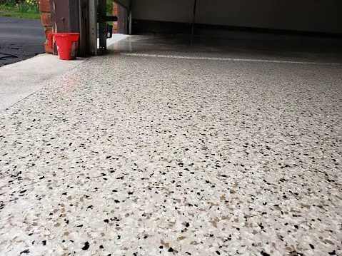A garage floor with white and black speckles.